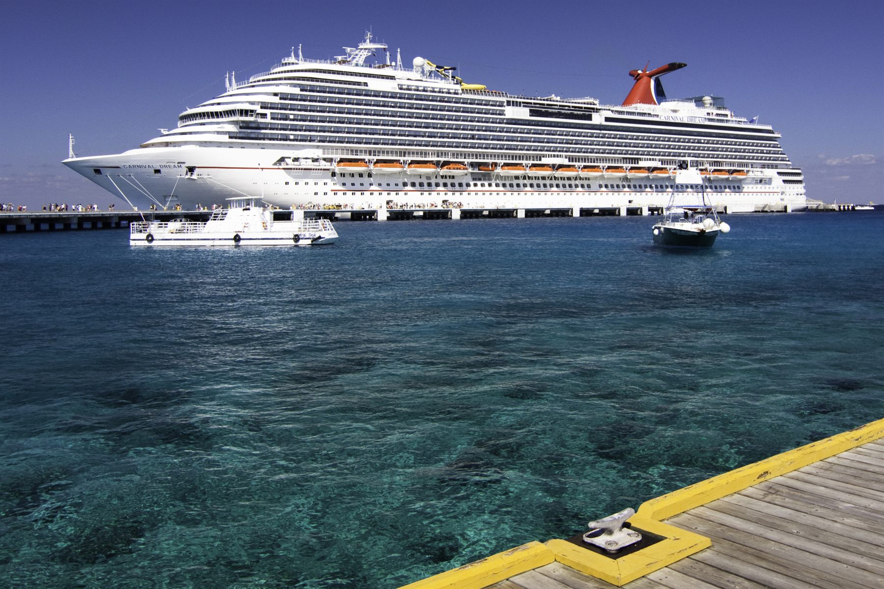 A cruise ship docked at a pier over clear turquoise water in Cozumel, Mexico