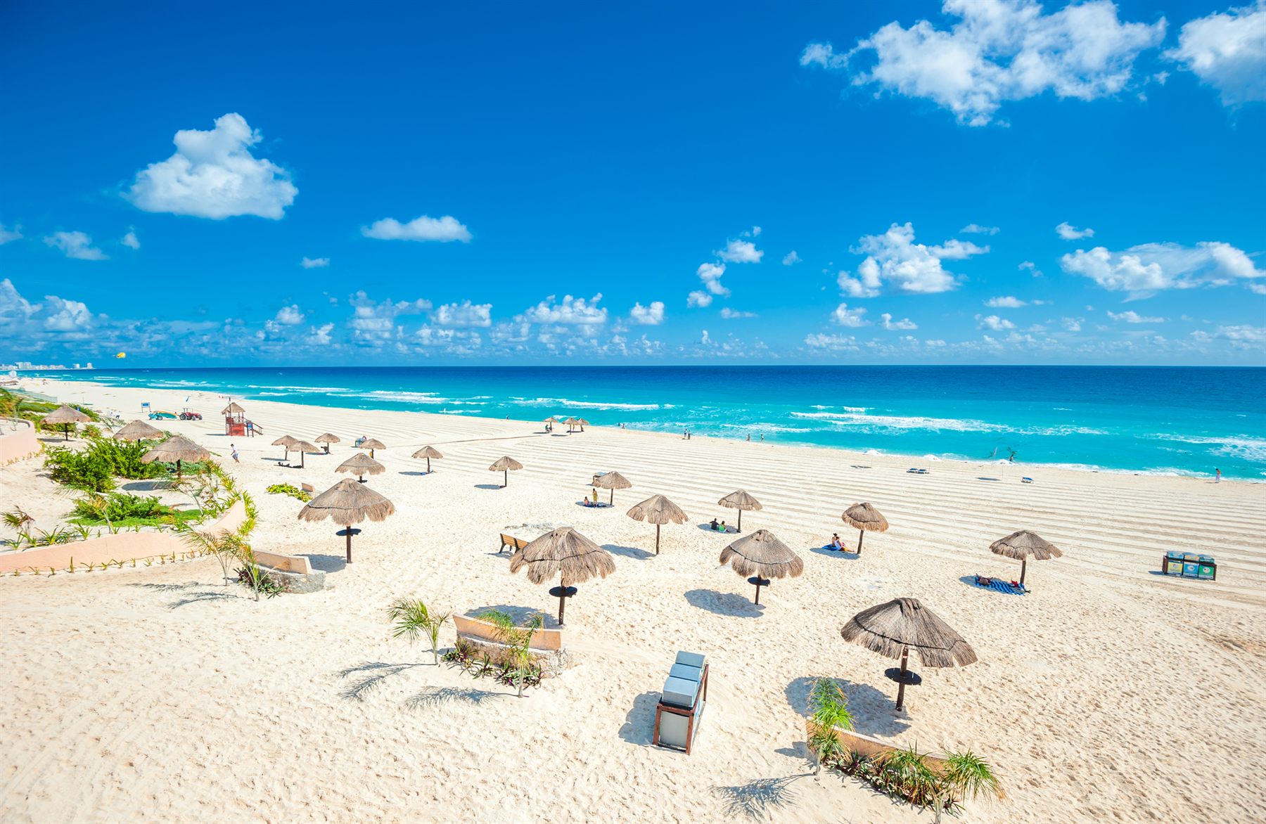 White-sand beach with thatched umbrellas and turquoise sea on Mexico’s Caribbean coast